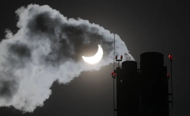 Smoke rises from chimney of a gas boiler house during partial solar eclipse in Moscow, 25 October 2022. From Moscow the sun will appear about 70 percent eclipsed as the moon passes between the Earth and the sun, obscuring the sun from view. (Photo by Maxim Shipenkov/EPA/EFE/Rex Features/Shutterstock)