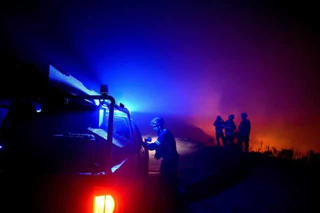 Firefighters gather to evaluate the progression of the wildfire at Calheta in Madeira island on August 12, 2016. Firefighters were making progress in quenching forest fires that have ravaged parts of Portugal and France, officials said on August 12, 2016, as Spain faced a rash of possibly deliberate blazes. The situation had calmed down on the frontline of fires in northern Portugal and on the island of Madeira where three people perished this week in the flames. (Photo by Patricia de Melo Moreira/AFP Photo)