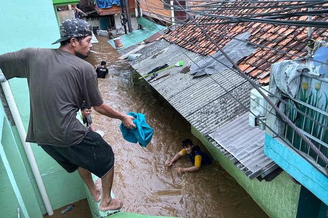 Residents look to evacuate during severe flooding in Jatinegara district in Jakarta on March 4, 2025. (Photo by Bagus Saragih/AFP Photo)