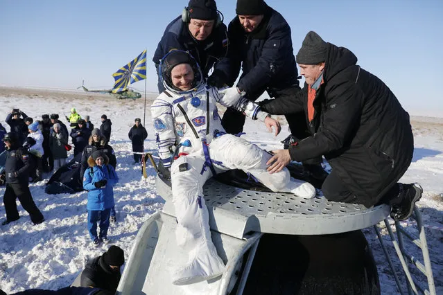 Russian space agency specialists help Russian cosmonaut Sergey Ryazanskiy shortly after the landing of the Russian Soyuz MS-05 space capsule about 150 km ( 80 miles) south-east of the Kazakh town of Zhezkazgan, Kazakhstan, Thursday, December 14, 2017. Three astronauts on Thursday landed back on Earth after nearly six months aboard the International Space Station. (Photo by Dmitri Lovetsky/AP Photo)
