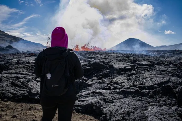 A person looks on the scene of the newly erupted volcano taking place in Meradalir valley, near mount Fagradalsfjall, Iceland on August 4, 2022. (Photo by Jeremie Richard/AFP Photo)