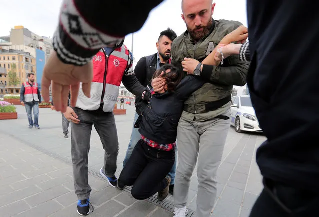 Plainclothes police officers detain a protester as she and others attempt to defy a ban and to gather at Taksim Square to celebrate May Day, in central Istanbul, Turkey May 1, 2017. (Photo by Kemal Aslan/Reuters)