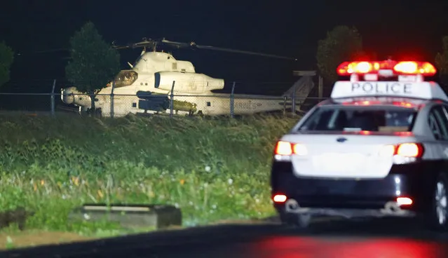 U.S. Marine Corps AH-1 attack helicopter sits near a Japanese police vehicle in Yomitan village, Okinawa, Japan, Monday, January 8, 2018. The U.S. military helicopter with two people aboard made an emergency landing in a field at a waste disposal site on Okinawa islands in the second such incident in three days. No injuries were reported. (Photo by Takuto Kaneko/Kyodo News via AP Photo)