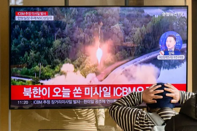 A man watches a television showing a news broadcast with file footage of a North Korean missile test, at a railway station in Seoul on November 18, 2022. A suspected intercontinental ballistic missile launched by North Korea on Friday is believed to have fallen in Japan's exclusive economic waters, Japanese Prime Minister Fumio Kishida said. (Photo by Anthony Wallace/AFP Photo)