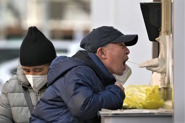 A resident has his COVID-19 throat swabbed at a coronavirus testing site in Beijing, Wednesday, December 14, 2022. (Photo by Andy Wong/AP Photo)