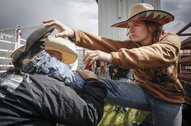 Emma Eastwood, from Lacombe, Alberta, stretches before competing in women's ranch bronc during rodeo action in Crossfield, Alberta, Saturday, June 14, 2025. (Photo by Jeff McIntosh/The Canadian Press via AP Photo)