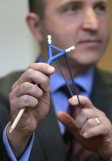 James Swartz, director of World Against Toys Causing Harm Inc., pulls back the rubber band on a Catapencil, a combination pencil and slingshot, at Children's Franciscan Hospital in Boston, Wednesday, November 19, 2014. (Photo by Charles Krupa/AP Photo)