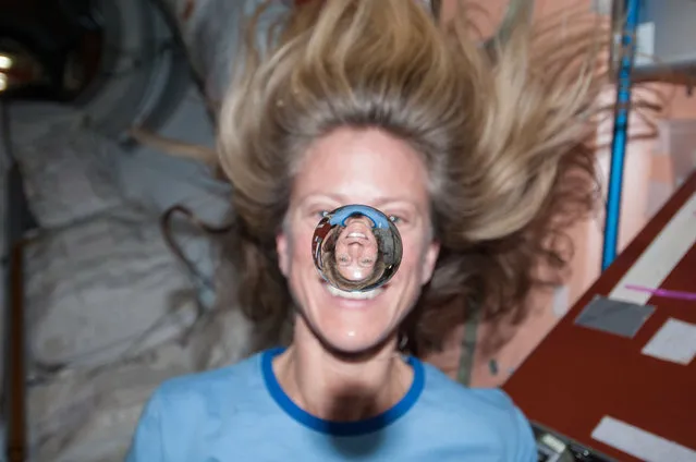 NASA astronaut Karen Nyberg watches a water bubble float freely between her and the camera, showing her image refracted in the droplet, February 7, 2018. (Photo by NASA)