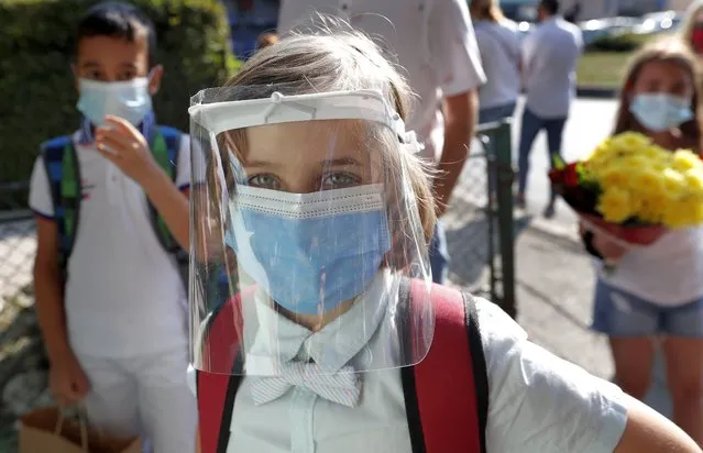 A student wearing a face shield waits to enter during his first day of school at “George Enescu” National College of Music in Bucharest, Romania, 14 September 2020. Children get accustomed with health safety measures and receive textbooks and timetables for the first semester. (Photo by Robert Ghement/EPA/EFE)