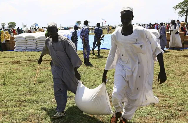 Men carry a sack after receiving food provided by the United Nations' World Food Programme (WFP) during a visit by a European Union delegation, at an Internally Displaced Persons (IDP) camp in Azaza, east of Ad Damazin, capital of Blue Nile state, Sudan October 21, 2015. (Photo by Mohamed Nureldin Abdallah/Reuters)