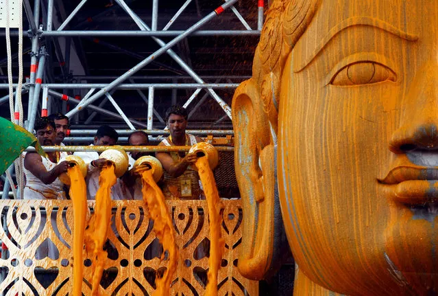 Devotees pour turmeric paste on the monolithic statue of Jain god Gomateshwara as they celebrate the Mahamastakabhisheka, or head anointing ceremony of the statue, in Shravanabelagola, India February 17, 2018. (Photo by Abhishek N. Chinnappa/Reuters)