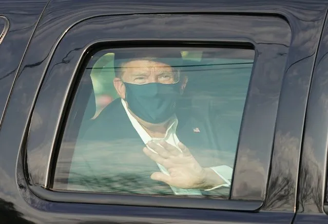 US President Trump waves from the back of a car in a motorcade outside of Walter Reed Medical Center in Bethesda, Maryland on Ocotber 4, 2020. (Photo by Alex Edelman/AFP Photo)