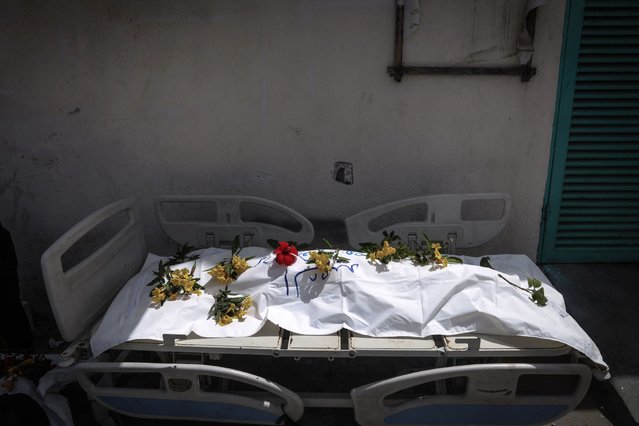 A body unearthed at Nasser Hospital is set on a stretcher and covered with flowers before being buried in Khan Younis, Gaza, on Tuesday, April 23, 2024. Nearly 400 bodies have been found in mass graves at the hospital following Israeli troops' withdrawal from the area earlier this month, the Palestinian Civil Defense in Gaza said on Thursday. The Israel Defense Forces has said any suggestion that it buried Palestinian bodies in mass graves was false, and that a grave at the Nasser complex was dug by Palestinians in Gaza some months ago. (Photo by AFP Photo/Stringer)