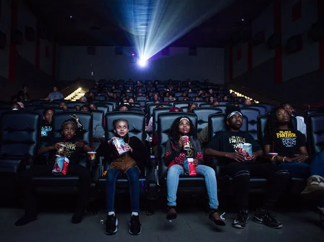 Flint resident Mari Copeny, also known as Little Miss Flint, third from left, takes a sip of her soda as she watches a free screening of the film “Black Panther” with more than 150 Flint children after she raised $16,000 to provide free tickets in an entire theater on Monday, Feb. 19, 2018 at Rave Cinemas Flint West 14 in Flint Township, Mich. Mari also gave away $2,000 in Black Panther toys and comic books at the screening. She said she is happy to see the film with her squad, pictured from left, Savannah Brown, Ayanna Johnson and Braylon Copeny. “Kids in Flint always see themselves portrayed in the media as victims. Black Panther gives Flint kids a chance to see themselves represented on the big screen as royalty and heroes”, Copeny said. “Representation across all forms of media is important, especially in media that children consume”, Copeny said. “You can be your own hero. You can be a superhero, but ultimately you're your own hero. “Black Panther” teaches us that we can be whoever you want to be. And that especially goes for Flint kids”. (Photo by Jake May /The Flint Journal-MLive.com via AP Photo)