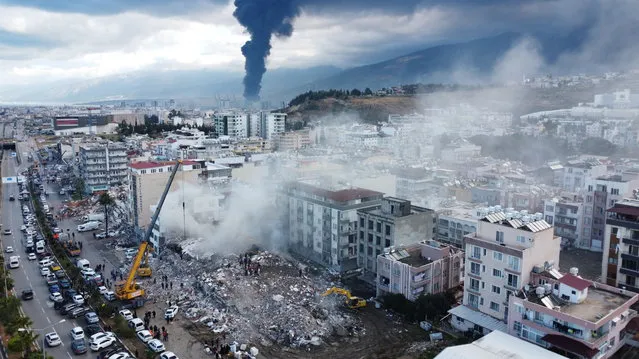 Smoke billows from the Iskenderun Port as rescue workers work at the scene of a collapsed building on February 07, 2023 in Iskenderun, Turkey. (Photo by Burak Kara/Getty Images)