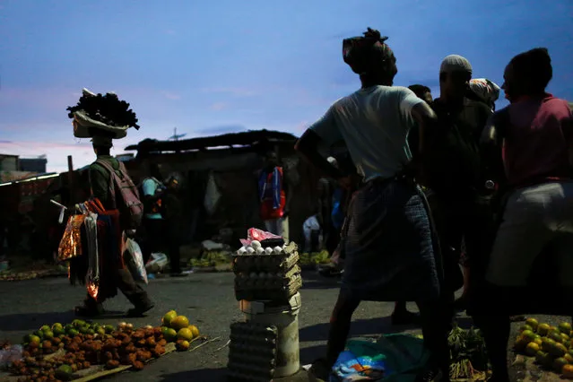 Vendors wait for clients at a street market while Hurricane Matthew approaches in Port-au-Prince, Haiti, October 2, 2016. (Photo by Carlos Garcia Rawlins/Reuters)