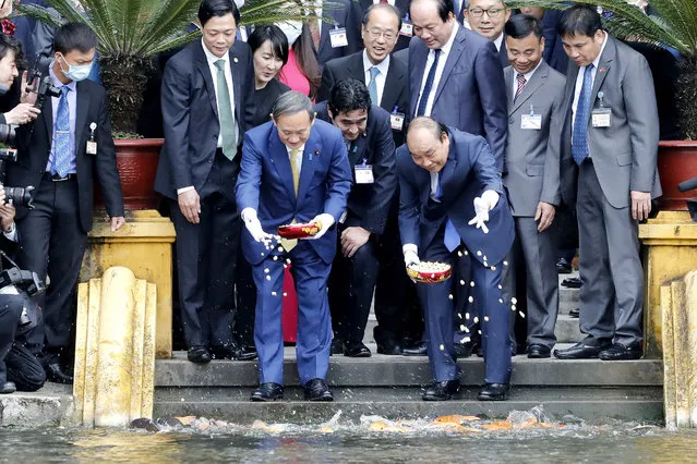 Japanese Prime Minister Yoshihide Suga, center left, and his Vietnamese counterpart Nguyen Xuan Phuc, center right, feed the fish by a pond at the Presidential Palace compound in Hanoi, Vietnam, Monday, October 19, 2020. (Photo by Minh Hoang/AP Photo/Pool)