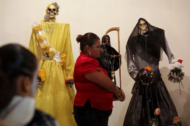 A woman carries a figurine of La Santa Muerte (Saint Death) at a shrine during Day of the Dead celebrations in Ciudad Juarez, Mexico, November 2, 2015. (Photo by Jose Luis Gonzalez/Reuters)