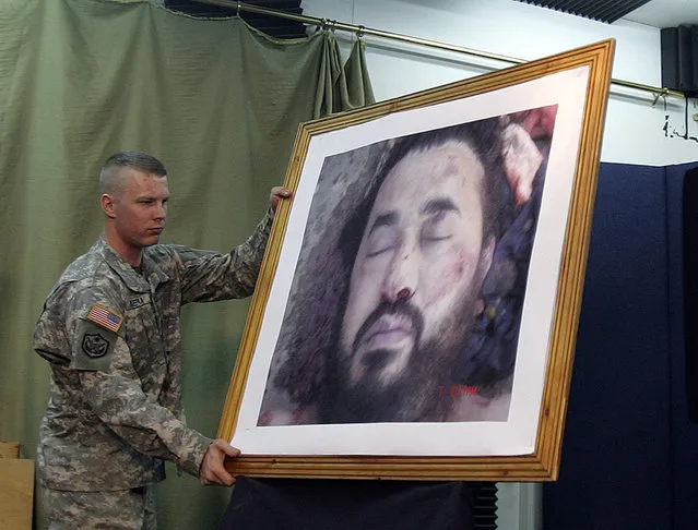 A U.S. soldier displays the picture of the dead Al Qaeda leader in Iraq, Abu Musab al-Zarqawi, during a news conference at the fortified Green Zone in Baghdad, June 8, 2006. (Photo by Ceerwan Aziz/Reuters)