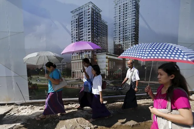 People walk by a construction site of new apartment buildings in Yangon November 4, 2015. (Photo by Jorge Silva/Reuters)