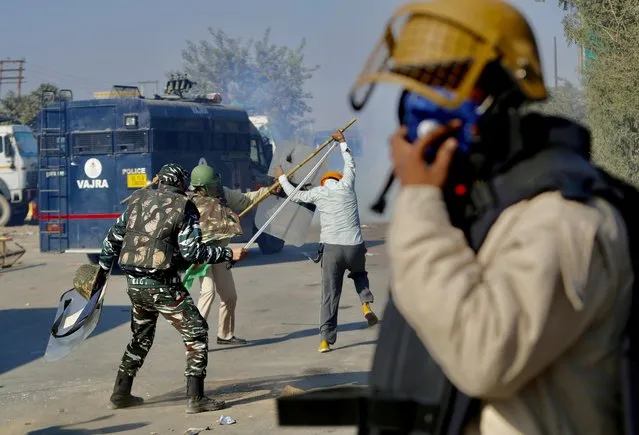 Policemen beat a protesting farmer, at the border between Delhi and Haryana state, Friday, November 27, 2020. (Photo by Manish Swarup/AP Photo)