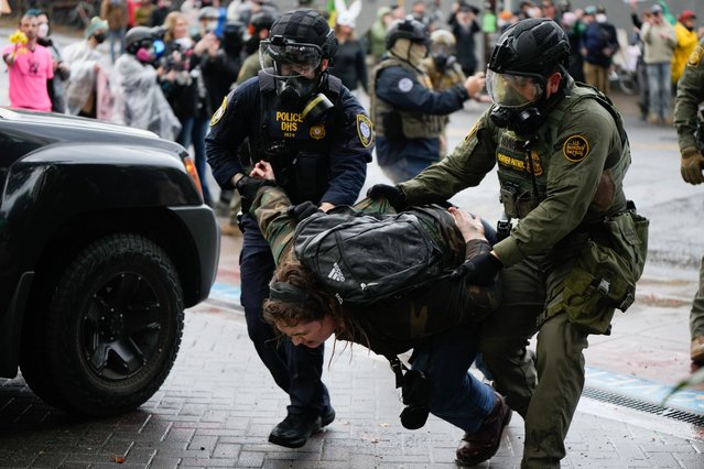 A protester is detained outside the U.S. Immigration and Customs Enforcement facility on Sunday, October 12, 2025, in Portland, Ore. (Photo by Jenny Kane/AP Photo)
