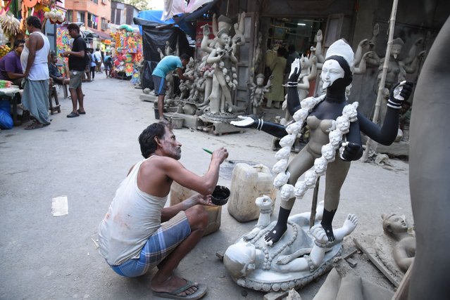 An artisan gives the final touches to an idol of the Hindu goddess Kali on the eve of the Hindu festival of Diwali at Kumortuli, the traditional potters' quarter in northern Kolkata on October 14, 2025. (Photo by Dipa Chakraborty/Pacific Press/Rex Features/Shutterstock)