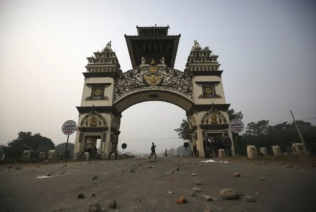 A member of the Nepalese Armed Police Force walks along the Shankaracharya Gate at the Nepalese-Indian border, as stones thrown by the protesters are scattered on the road during a general strike called by Madhesi protesters demonstrating against the new constitution in Birgunj, Nepal November 5, 2015. (Photo by Navesh Chitrakar/Reuters)