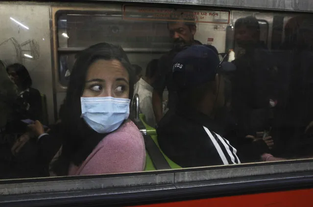 A commuter in the metro wears a protective mask as a precaution against the spread of the new coronavirus in Mexico City, Thursday, March 19, 2020. (Photo by Marco Ugarte/AP Photo)