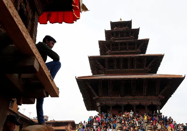 A boy sits on the chariot of God Bhairab as people gather for the Biska Festival also known as Bisket festival in Bhaktapur, Nepal April 10, 2018. (Photo by Navesh Chitrakar/Reuters)