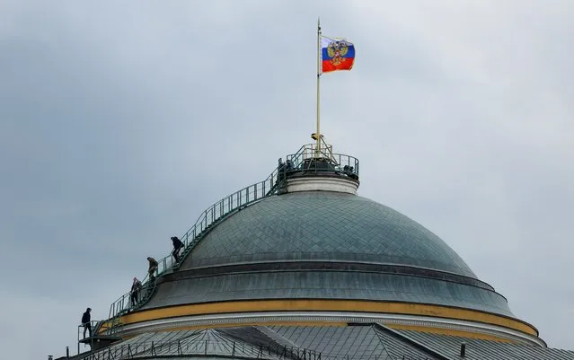 People gather on the dome of the Kremlin Senate building in central Moscow, Russia on May 3, 2023. (Photo by Evgenia Novozhenina/Reuters)