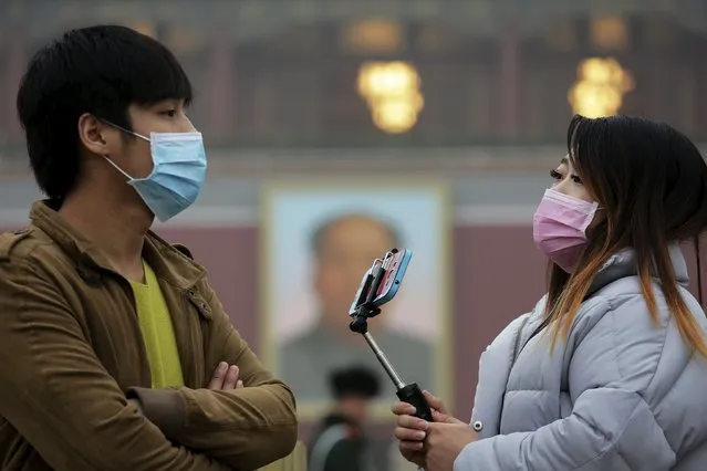 A couple wearing protective masks visit the Tiananmen Gate on an extremely polluted day as hazardous, choking smog continues to blanket Beijing, China December 1, 2015. (Photo by Damir Sagolj/Reuters)