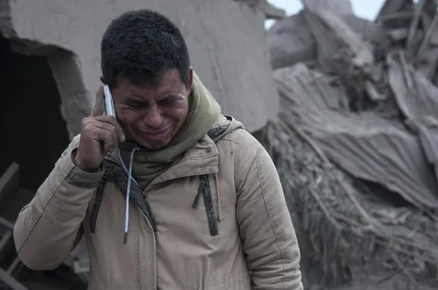 Boris Rodriguez, 24, who is searching for his wife, cries after seeing the condition of his neighborhood, destroyed by the erupting Volcan de Fuego, or “Volcano of Fire”, in Escuintla, Guatemala, Monday, June 4, 2018. The volcano exploded Sunday, sending ash high into the sky and lava flows cascading into rural hamlets on the mountain's slopes. (Photo by Oliver de Ros/AP Photo)