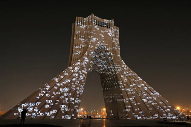 The video mapping is projected on Tehran's iconic Azadi(freedom) tower to commemorate 176 victims of the Ukrainian flight during a municipal memorial marking the first anniversary of the plane crash, in Tehran, Iran, Wednesday, January 6, 2021. (Photo by Ebrahim Noroozi/AP Photo)