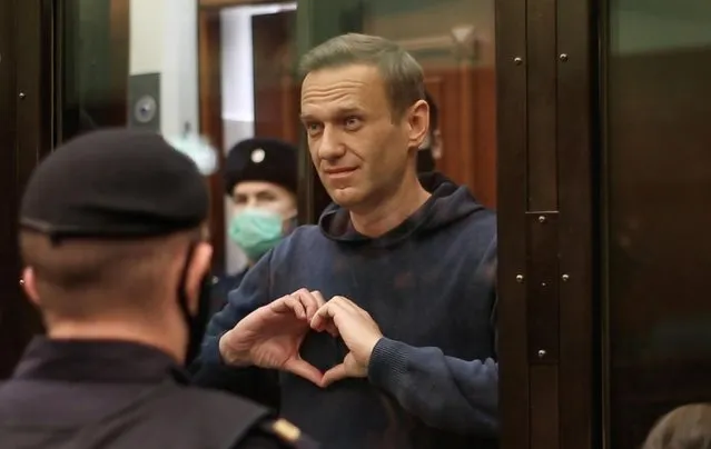 A still image taken from video footage shows Russian opposition leader Alexei Navalny making a hand heart gesture during the announcement of a court verdict in Moscow, Russia on February 2, 2021. (Photo by Press Service of Simonovsky District Court/Handout via Reuters)