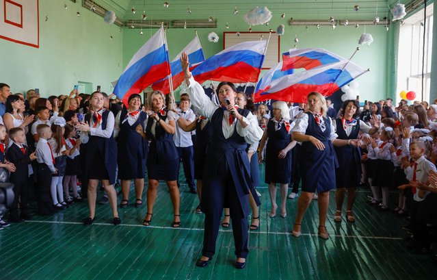 People take part in a ceremony marking the start of a new school year at a lyceum in the course of Ukraine-Russia conflict in Donetsk, Russian-controlled Ukraine, on September 2, 2024. (Photo by Alexander Ermochenko/Reuters)