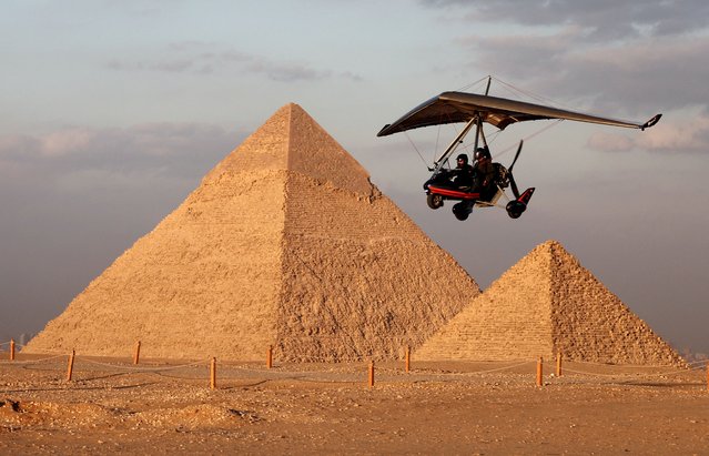 A tourist flies with an Ultralight trike pilot near the Great Pyramids of Giza, on the outskirts of Cairo, Egypt, on November 15, 2025. (Photo by Mohamed Abd El Ghany/Reuters)