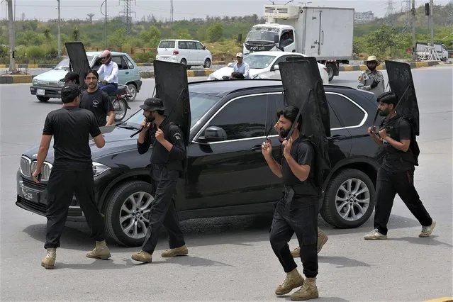 Security personnel secure a vehicle carrying the Pakistan's former Prime Minister Imran Khan leaves after his court appearance, in Islamabad, Pakistan, Tuesday, May 23, 2023. Khan on Tuesday pressed his legal battle before a court in the capital, Islamabad, which granted him protection from arrest until early next month in several cases where he faces terrorism charges for inciting violence. (Photo by Anjum Naveed/AP Photo)
