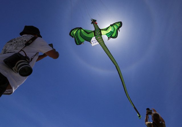Journalists photograph kites during a practice run at Dolphin Beach ahead of this weekend's 30th Cape Town International Kite Festival, an awareness campaign for World Mental Health Day where kite enthusiasts gather to fly colourful kites to raise funds for mental health support, in Cape Town, South Africa, on October 22, 2024. (Photo by Esa Alexander/Reuters)