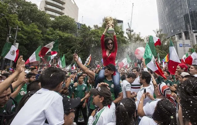 In this Saturday, June 23, 2018 photo, soccer fans and gay pride parade revelers converge on Reforma Avenue in Mexico City. Soccer fans were celebrating Mexico's victory over Korea at a World Cup soccer match in Russia as they met the massive gay pride parade marching toward downtown. (Photo by Christian Palma/AP Photo)