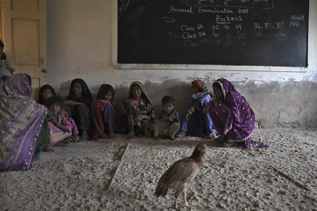 Women and children take shelter in a school building after fleeing from their villages due to Cyclone Biparjoy approaching, at a costal area of Badin district, in Pakistan's Sindh province, Tuesday, June 13, 2023. Pakistan's army and civil authorities are planning to evacuate 80,000 people to safety along the country's southern coast, and thousands in neighboring India sought shelter ahead of Cyclone Biparjoy, officials said. (Photo by Umair Rajput/AP Photo)