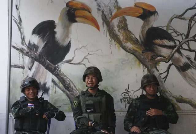 Soldiers guard outside Parliament as National Legislative Assembly members vote during an impeachment hearing for ousted former Prime Minister Yingluck Shinawatra, in Bangkok, January 23, 2015. Thai authorities dealt a double blow to Yingluck and her powerful family on Friday, banning her from politics for five years and proceeding with criminal charges for negligence that could put her in jail. (Photo by Chaiwat Subprasom/Reuters)