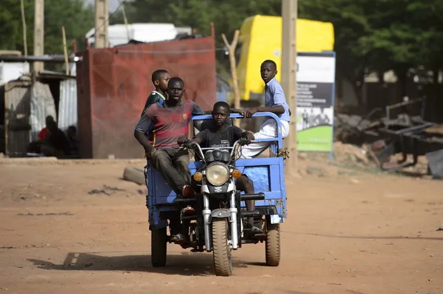 Young men ride a motorcycle cart through the streets of Bamako, Mali, Africa on Saturday, June 23, 2018. (Photo by Sean Kilpatrick/The Canadian Press via AP Photo)