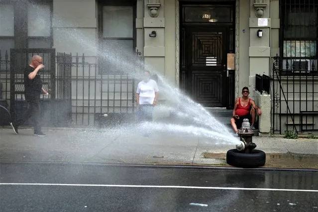 People try to cool off near an open fire hydrant during hot weather in Manhattan in New York City, New York, U.S., July 17, 2023. (Photo by Mike Segar/Reuters)