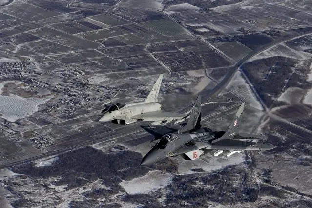 A Polish Air Force MIG-29 fighter (R) and an Italian Air Force Eurofighter Typhoon fighter patrol over the Baltics during a NATO air policing mission from Zokniai air base near Siauliai February 10, 2015. (Photo by Ints Kalnins/Reuters)