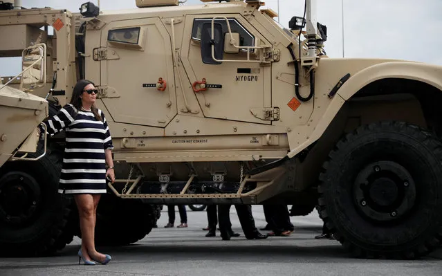 White House Press Secretary Sarah Huckabee Sanders watches from beside an Army vehicle as President Donald Trump observes a military demonstration on August 13, 2018. (Photo by Carlos Barria/Reuters)