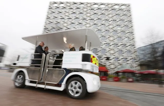 People ride a prototype of a driverless vehicle as it is moves through a pedestrian area in Greenwich, east London, February 11, 2015. (Photo by Suzanne Plunkett/Reuters)
