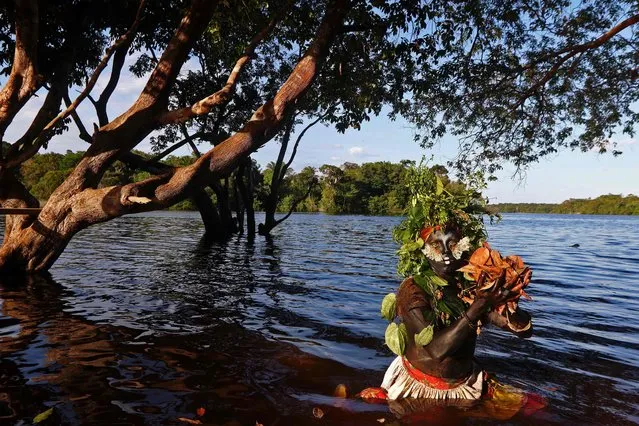 Artist and activist Emerson Munduruku is pictured as he teaches environmental conservation to children through his drag queen alter ego character Uyra Sodoma, at the Sustainable Reserve of Anavilhanas in the state of Amazonas in northern Brazil, on July 21, 2018. Emerson's drag character requires two hours of preparation and all the materials he uses are collected from nature - never using the same costume twice. He's a descendent of the Munduruku indigenous tribe from the Brazilian Amazon and travels to remote communities to teach children about the importance of the environment. (Photo by Ricardo Oliveira/AFP Photo)