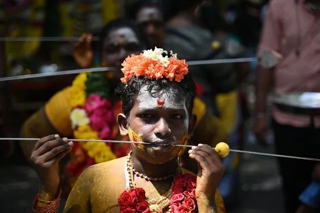 Devotees pierce their cheeks with a metal rod during a religious procession to celebrate Aadi festival in Chennai on July 30, 2023. (Photo by R. Satish Babu/AFP Photo)