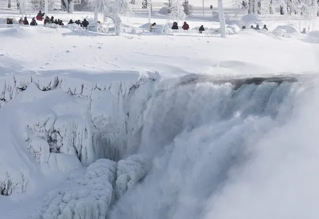 Niagara Falls State Park visitors look over masses of ice formed around the American Falls, photographed from across the Niagara River in Niagara Falls, Ontario, Canada, Thursday, February 19, 2015. (Photo by Aaron Lynett/AP Photo/The Canadian Press)